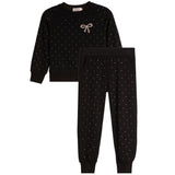 A two-piece kids' loungewear set in black, featuring a long-sleeve sweatshirt with a small bow embellishment on the chest and matching jogger pants, both decorated with tiny white polka dots.
