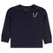 A navy blue long-sleeve crewneck shirt with a chest pocket featuring two white-and-black patterned pencils, shown against a plain white background.