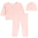 A three-piece baby clothing set in light pink, featuring a long-sleeve wrap top, matching pants, and a knit beanie, all decorated with a subtle metallic gold bow pattern.