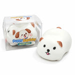 A white puppy-shaped squishy toy with brown ears and a pink tongue, shown next to its clear plastic packaging box on a white background.