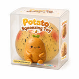 A potato-shaped squishy toy displayed inside a clear plastic retail box. The toy is a small cute potato character with a winking face, pink cheeks, and a green leaf on its head, sitting in front of a large round potato with speckles and blush marks.