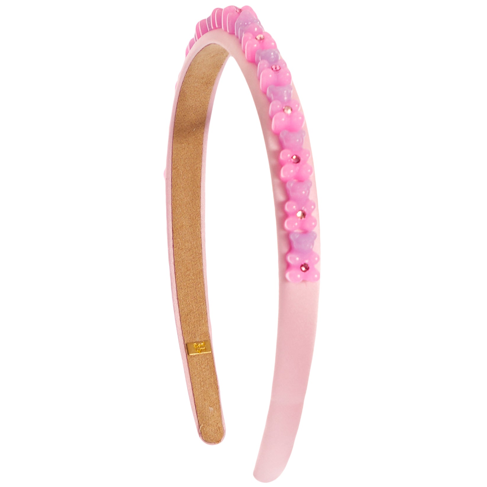 A light pink plastic headband decorated with a row of small pink and lavender flower charms and rhinestones on the outer band, shown against a plain white background.