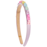A pastel lavender headband decorated with a row of colorful pastel beads and small pink flower charms, shown on a plain white background.