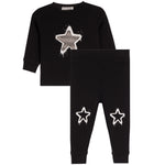 A toddler's two-piece black sweatshirt and jogger pants set. The long-sleeve sweatshirt features a large white and gray star graphic on the chest, while the matching jogger pants have two smaller white star graphics on the lower legs.