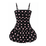 A black retro-style dress with pink polka dots, featuring a structured bustier top and a flared ruffled skirt, shown against a plain white background.