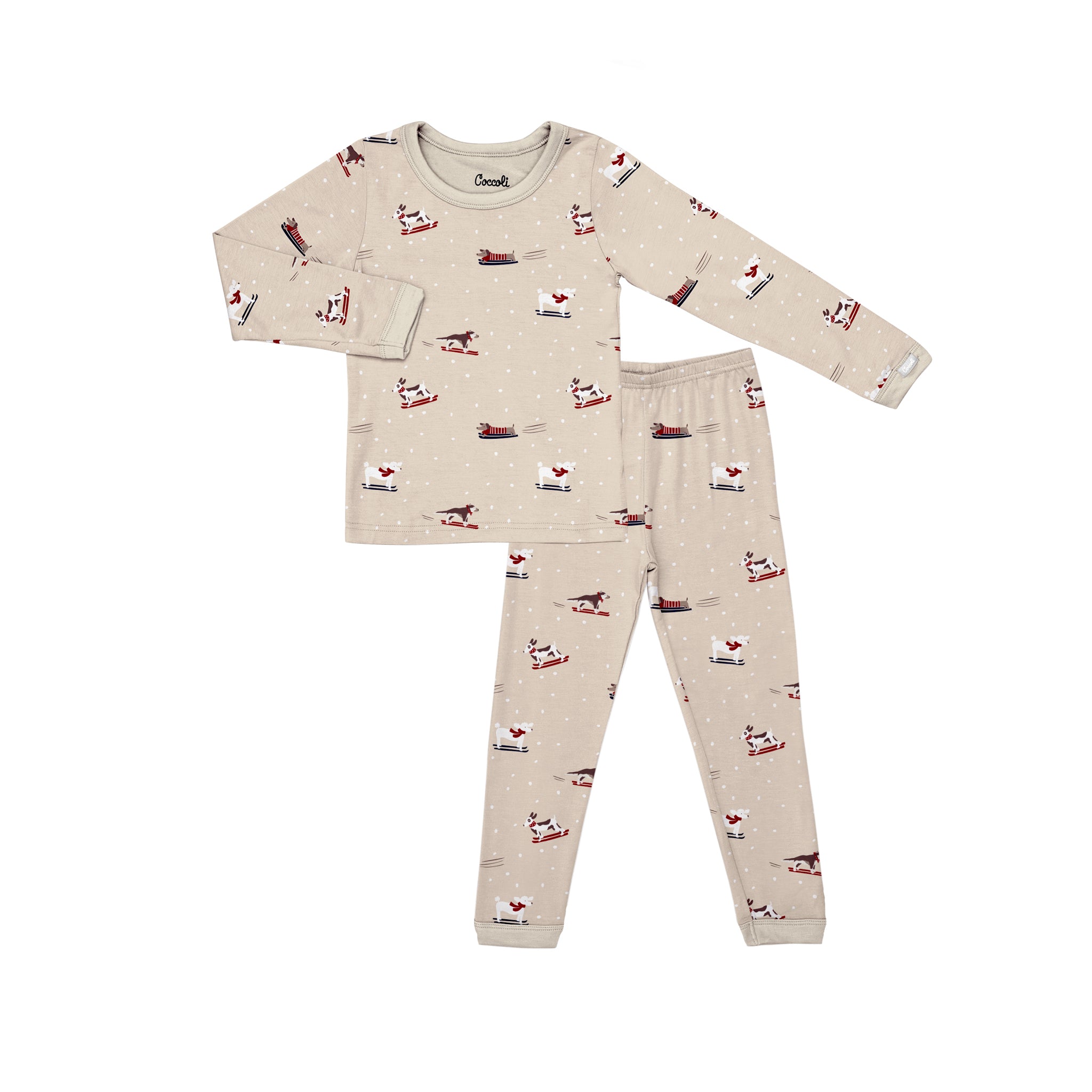 A two-piece children's pajama set featuring a long-sleeve top and matching pants in a light beige color, printed with a winter dogs on sleighs