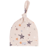 A baby knot hat in a light beige fabric with a pattern of hand-drawn stars in black, orange, and gray.