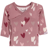 A baby long-sleeve wrap top in dusty rose pink, featuring an all-over heart pattern in shades of burgundy, cream, and light pink. The brand name 'Cococoll' is visible on the inner neck label.