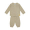 A two-piece baby loungewear set in a warm beige waffle-knit fabric, featuring a long-sleeve top with a small yellow brand patch on the sleeve and matching pants with a drawstring waist.