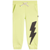 Light yellow-green jogger pants with a large black lightning bolt graphic on the right leg, featuring a white drawstring with black bolts.