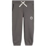 A pair of dark gray sweatpants with a white braided drawstring and a small white circular logo on the left thigh, shown against a plain white background.