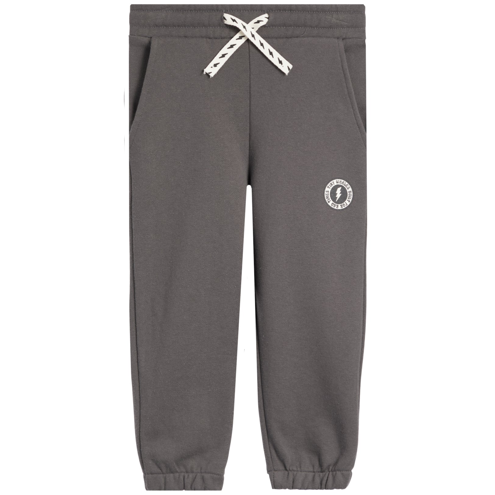 A pair of dark gray sweatpants with a white braided drawstring and a small white circular logo on the left thigh, shown against a plain white background.