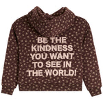 A dark brown hooded sweatshirt with a beige floral pattern and a large beige text graphic on the back that reads, 'BE THE KINDNESS YOU WANT TO SEE IN THE WORLD!'.