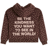 A dark brown hooded sweatshirt with a beige floral pattern and a large beige text graphic on the back that reads, 'BE THE KINDNESS YOU WANT TO SEE IN THE WORLD!'.
