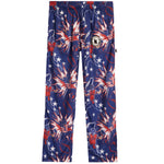 A pair of kids' pants featuring a patriotic American flag theme with stars, football players, and fireworks prints in navy blue, red, and white. A circular patch with a 'K' logo is visible on the left thigh.