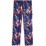 A pair of kids' pants featuring a patriotic American flag theme with stars, football players, and fireworks prints in navy blue, red, and white. A circular patch with a 'K' logo is visible on the left thigh.