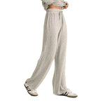 A person wearing light heather gray drawstring sweatpants with a matching cropped sweatshirt and white sneakers, shown against a plain white background.