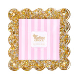 A square scalloped-edge photo frame filled with gold and silver glitter.