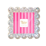 A square glittery photo frame with a scalloped edge and four hanging loops