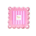A pink scalloped-edge square photo frame with four mounting holes, on a white background.
