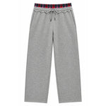 A pair of heather gray sweatpants featuring a decorative ruffled elastic waistband with a red, navy, and black plaid pattern, complete with a matching gray drawstring.