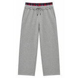 A pair of heather gray sweatpants featuring a decorative ruffled elastic waistband with a red, navy, and black plaid pattern, complete with a matching gray drawstring.