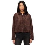 A woman modeling a cropped brown suede button-up shirt jacket with two front patch pockets, paired with dark jeans, against a plain white background.