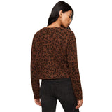 A woman shown from the back wearing a brown long-sleeve knit top with a black leopard print pattern against a plain white background.