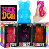 NeeDoh Gummy Bear toys in different translucent colors (pink, purple, orange) shown alongside a large blue bear and a hand squeezing a pink bear,
